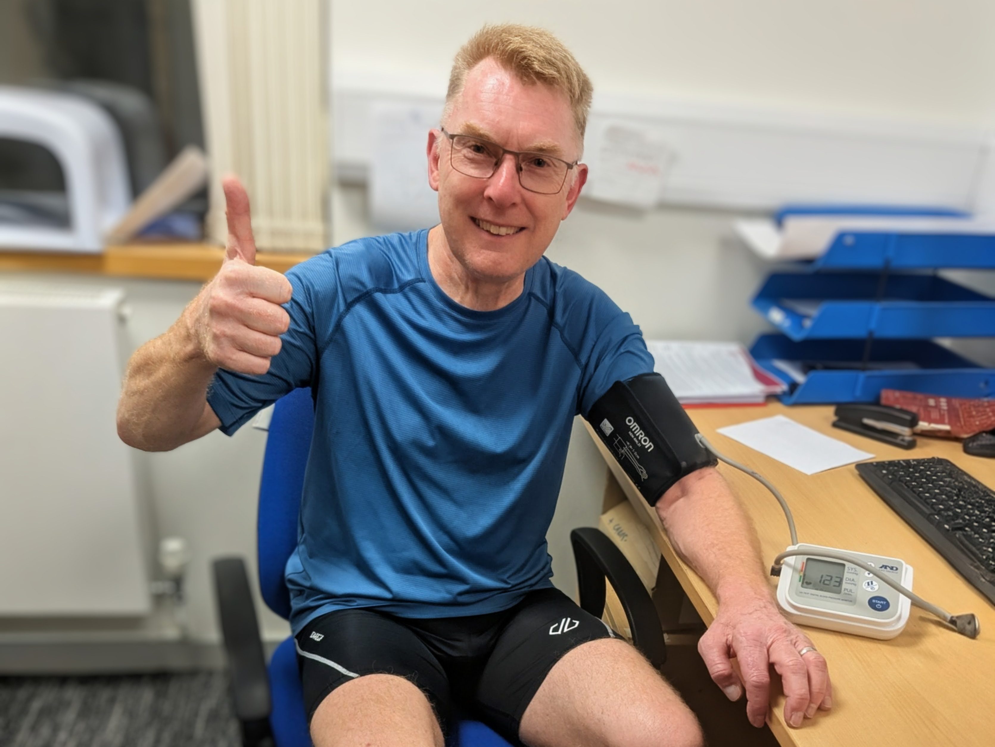 A man looking happy having his blood pressure checked.